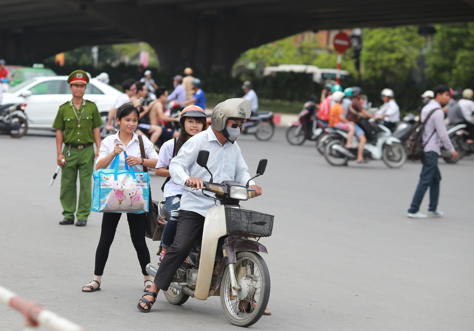Để tiết kiệm chi phí, các sĩ tử và người nhà lựa chọn phương án đi kẹp ba đến các bến xe. (Ảnh: Minh Sơn/Vietnam+)