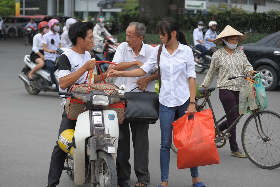 Để tiết kiệm chi phí, các sĩ tử và người nhà lựa chọn phương án đi kẹp ba đến các bến xe. (Ảnh: Minh Sơn/Vietnam+)