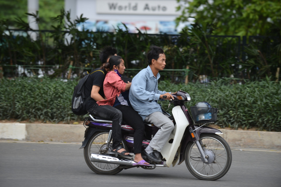 Một số gia đình chọn xe máy làm phương tiện di chuyển. (Ảnh: Minh Sơn/Vietnam+)