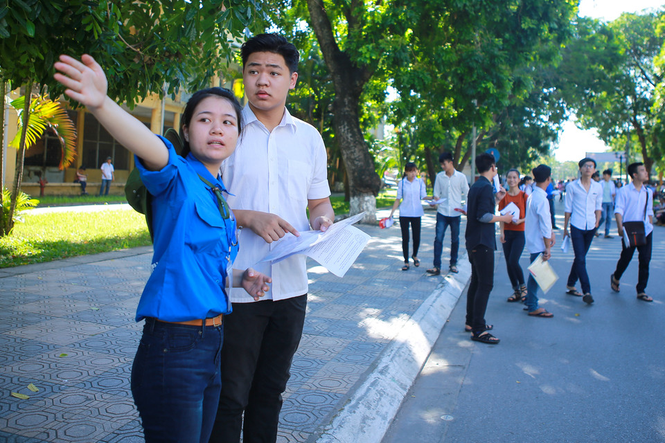 Hướng dẫn thí sinh đến phòng thi. (Ảnh: Minh Sơn/Vietnam+)