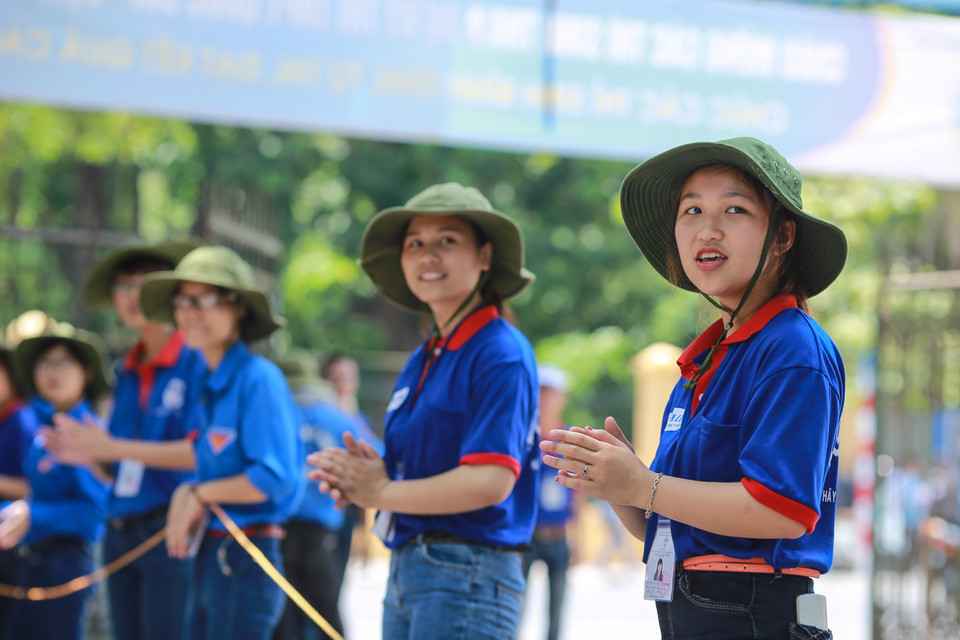 Dù vất vả nhưng các em vẫn nở nụ cười thật tươi chào đón những thí sinh đầu tiên ra khỏi phòng thi. (Ảnh: Minh Sơn/Vietnam+)