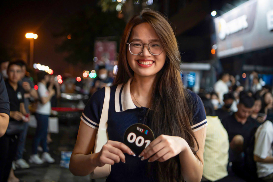 Từ 19 giờ tối 27/9, chị Vũ Thị Mỹ Hạnh (25 tuổi) đã cùng anh trai tới cửa hàng TopZone trên phố Xã Đàn (quận Đống Đa) xếp hàng chờ tới lượt nhận iPhone. Chị Hạnh may mắn là người đầu tiên được sở hữu sản phẩm đang được quan tâm nhất của Apple tại đại lý này. "Tôi rất hồi hộp nên đã quyết định tới sớm để chờ nhận máy. Thời gian qua tôi sử dụng chiếc iPhone 13 nhưng sau khi iPhone 16 ra mắt, tôi rất ấn tượng với sản phẩm này, đặc biệt ở phiên bản màu Titan Sa mạc nên đã quyết định đổi máy. Phiên bản tôi chọn là iPhone 16 Pro Max, 512Gb, màu Titan Sa mạc," chị Hạnh cho biết. (Ảnh: Minh Sơn/Vietnam+)