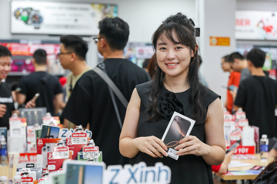 Là người đầu tiên nhận máy tại điểm bán lẻ CellphoneS Đại Cồ Việt, chị Bùi Thu Quỳnh (quận Hai Bà Trưng) cho biết năm nay chị đăng ký mua sản phẩm iPhone 16 Pro, lên đời từ chiếc iPhone 15 cũ. Theo chị Quỳnh đánh giá, năm nay iPhone 16 có nhiều điểm mới đáng giá như màn hình kích thước lớn hơn, camera hỗ trợ nhiều tính năng cho công việc chụp ảnh sản phẩm, phụ trợ cho công việc. (Ảnh: Minh Sơn/Vietnam+)