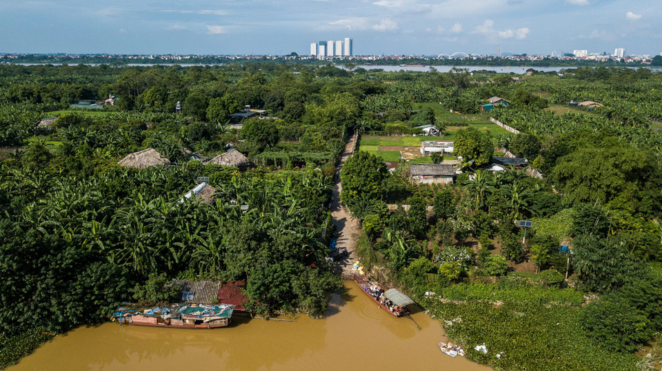 Dọc lối vào từ chân cầu Long Biên xuống bãi giữa sông Hồng (phường Ngọc Thụy, Long Biên, Hà Nội) nhiều đoạn nước ngập nửa bánh xe, thậm chí có nơi ngập nửa người. Người dân phải dùng thuyền để di chuyển qua đoạn nước ngập sâu. (Ảnh: PV/Vietnam+)