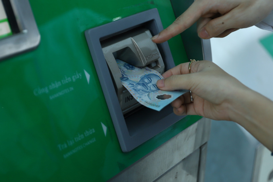Khách hàng đưa tiền vào khe nhận tiền để thực hiện thanh toán, số tiền phụ thuộc vào quãng đường di chuyển. (Ảnh: Hoài Nam/Vietnam+)