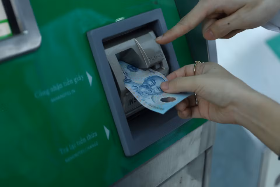 Khách hàng đưa tiền vào khe nhận tiền để thực hiện thanh toán, số tiền phụ thuộc vào quãng đường di chuyển. (Ảnh: Hoài Nam/Vietnam+)