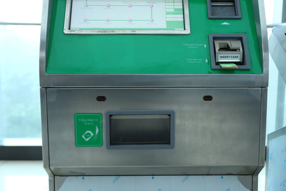 Khách hàng lấy vé ở cổng nhận vé phía dưới màn hình hiển thị thông tin. (Ảnh: Hoài Nam/Vietnam+)