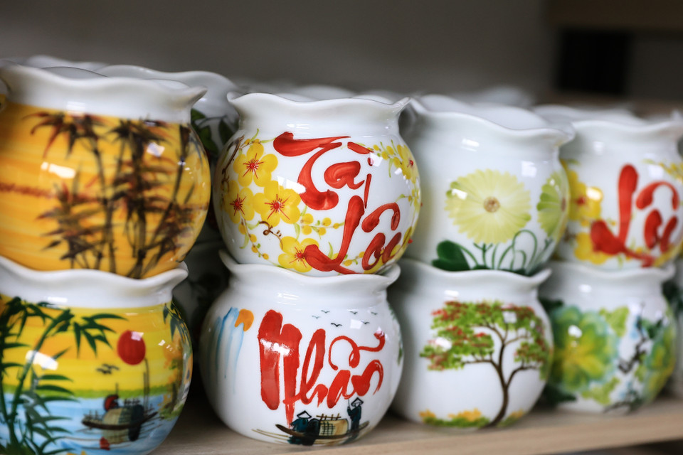 Ngoài ra còn rất nhiều sản phẩm khác đặc biệt là các vật dụng trong gia đình cũng được ‘khoác’ lên mình đặc trưng của ngày Tết như: Lọ hoa Tài Lộc, bát đĩa vẽ hoa mai, hộp đựng mứt Tết vô cùng đẹp mắt… (Ảnh: Hoài Nam/Vietnam+)