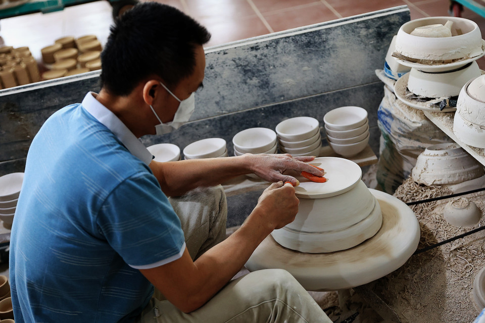 Chủ cơ sở sản xuất đồ gốm Tân Long cho biết: 'Cả năm nay lượng hàng khách đặt so với mọi năm có giảm nhưng đơn khách đặt hàng Tết vẫn giữ ổn định như năm trước.’ Ngoài những khách quen, cơ sở còn có những khách tỉnh mới với nhu cầu đặt hàng để bán online. (Ảnh: Hoài Nam/Vietnam+)