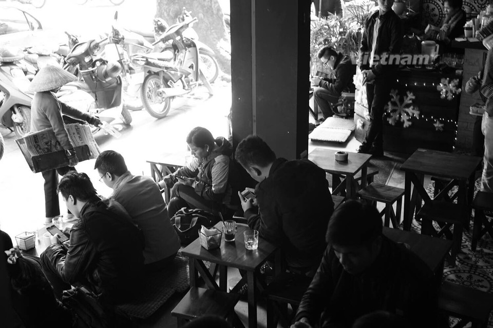 Thư thả gọi một cốc càphê, nhìn ngắm mọi người qua lại hoặc trò chuyện với bạn bè, đó cũng là lí do nhiều người thích ngồi những quán càphê vỉa hè. (Ảnh Hoàng Long-Thành Nguyễn/Vietnam+)