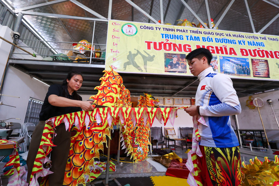 Để gắn được những chiếc vảy lên thân rồng rất phức tạp. Anh Tưởng cho hay mỗi con rồng dài gần 20 mét nhưng mỗi mét anh phải gắn mấy trăm vảy trên thân rồng để làm sao khi biểu diễn được dễ dàng. Quá trình hoàn thiện phần khung kết hợp nhiều công đoạn khác như trang trí cắt giấy, vải,... yêu cầu người thợ phải như họa sĩ tạo hình thực thụ. (Ảnh: Minh Sơn/Vietnam+)