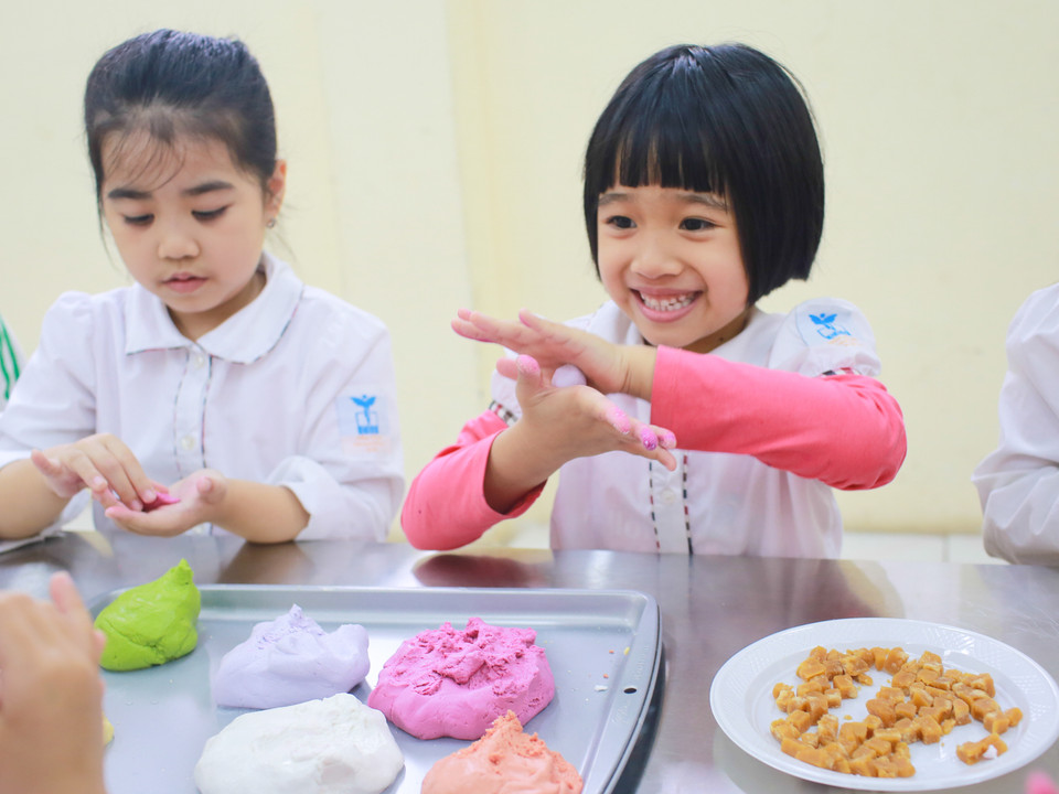 Các bé học sinh được hướng dẫn chi tiết từ cách nhào bột, nặn viên nhỏ cho đến luộc và vớt bánh. (Ảnh: Minh Sơn/Vietnam+)