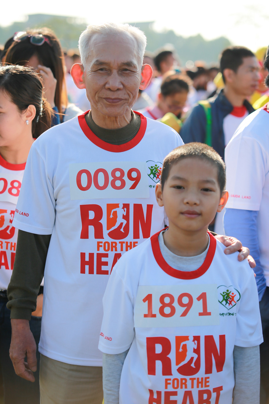 Ông Trần Viết Định (78 tuổi, Thanh Xuân) cùng với cháu trai mình tham gia ngày hội từ thiện. Ông cho biết muốn dẫn cháu mình tham gia hoạt động đầy ý nghĩa này. (Ảnh: Minh Sơn/Vietnam+)