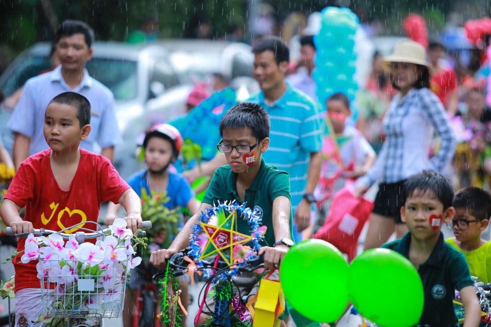 Khi đang diễu hành, trời bỗng nhiên mưa nhỏ khiến các phụ huynh lo lắng. (Ảnh: Minh Sơn/Vietnam+)