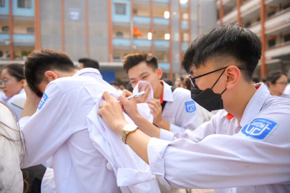 Những dòng chữ viết vội, lưu lại trên áo sẽ giúp các học sinh nhớ mãi về một thời học trò hồn nhiên, mơ mộng. (Ảnh: Quỳnh Anh/Vietnam+)