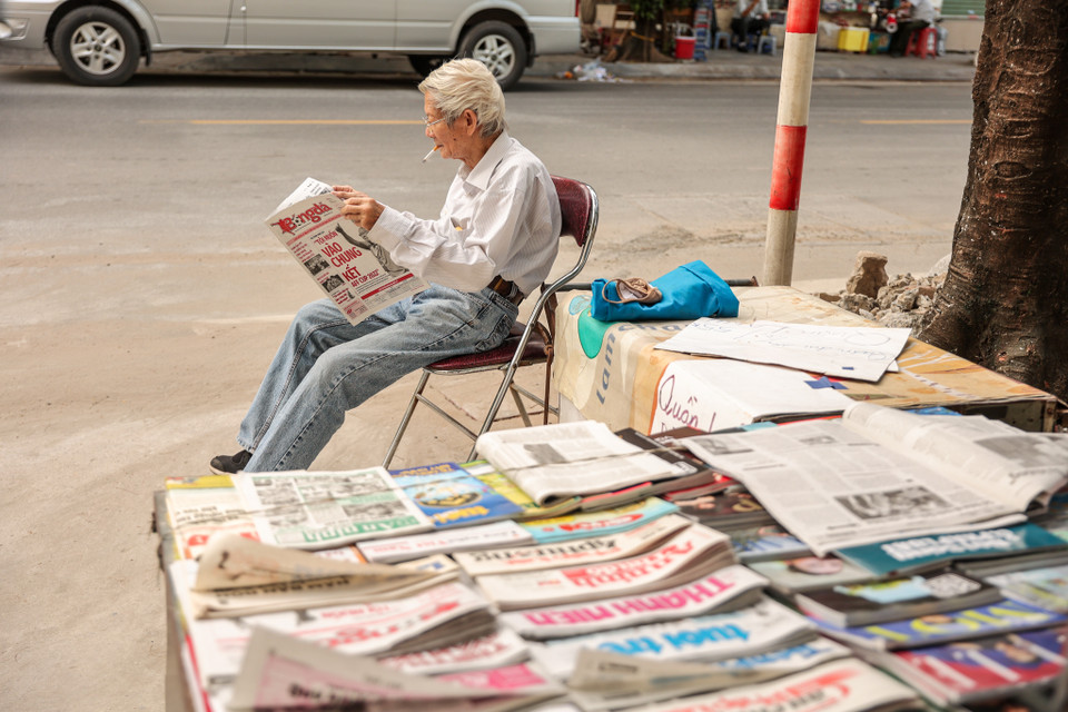 Thời buổi công nghệ thông tin phát triển, nhu cầu mua báo giấy ngày càng giảm. Những sạp báo in trên vỉa hè Hà Nội ngày một thưa thớt dần. Chính vì thế tìm kiếm được một sạp báo hay một người đọc báo không hề dễ dàng. (Ảnh: Minh Sơn/Vietnam+)