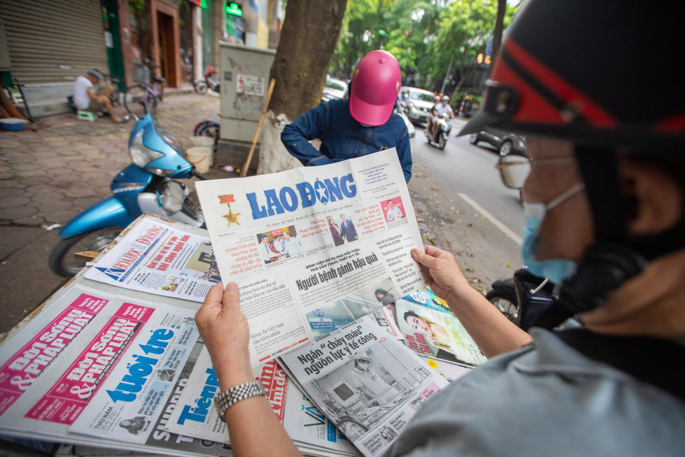 Khách hàng lui tới những sạp báo chủ yếu của chị là những người ngoài 50 tuổi và hầu hết là khách quen, lượng mua giảm nhiều nên mỗi ngày những sạp báo nhỏ như của chị Hòa chỉ dám nhập về 30 tờ một ngày. (Ảnh: Hoài Nam/Vietnam+)