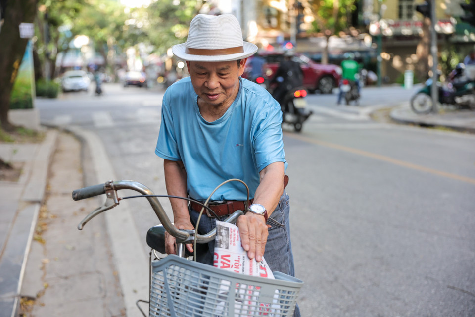 Ông Trần Minh Thư (85 tuổi) cho biết đến giờ vẫn lựa chọn báo giấy thay vì đọc báo điện tử do thói quen. Hàng ngày ông vẫn đạp xe đi mua báo rồi kiếm một quán cà phê để vừa thưởng thức vừa nghiền ngẫm tờ báo. (Ảnh: Minh Sơn/Vietnam+)