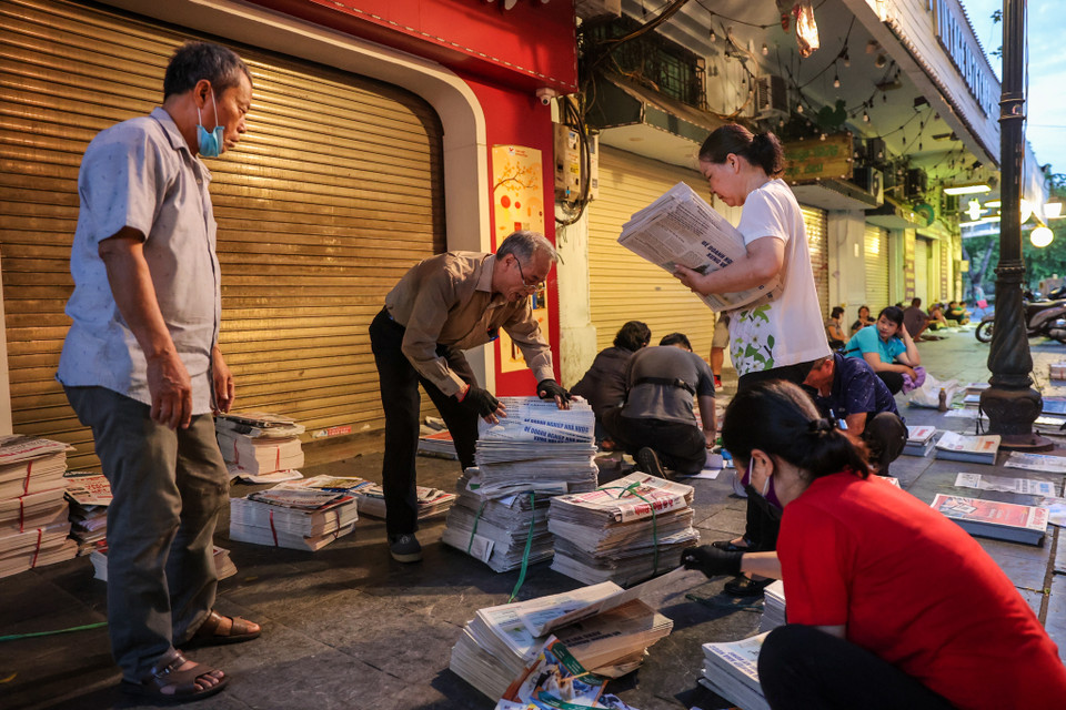 'Công việc hàng ngày của tôi bắt đầu từ 4 giờ đến 8 giờ sáng. Sau khi phân loại tôi sẽ đi giao báo hàng chục cây số xung quanh Hà Nội. Công việc tuy vất vả nhưng vui lắm,' ông Thuần chia sẻ. (Ảnh: Minh Sơn/Vietnam+)