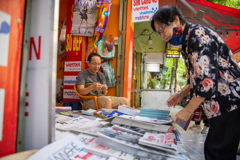 Cũng như chị Hòa, anh Đặng Hữu Phán vẫn duy trì sạp báo của mình đã hơn 30 năm nay nhưng lượng báo bán ra mỗi ngày khoảng 100 tờ. Những khách hàng lui tới chủ yếu là các cụ già trong phố cổ. (Ảnh: Hoài Nam/Vietnam+)
