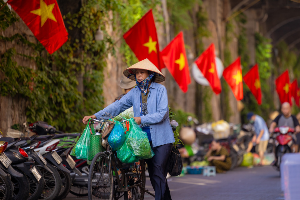 Hình ảnh những lá cờ đỏ sao vàng treo rợp trên đường phố hay trong ngõ đó là một hình ảnh đẹp, một câu chuyện đẹp mà mỗi người chúng ta cần gìn giữ và phát huy. (Ảnh: Minh Sơn/Vietnam+)