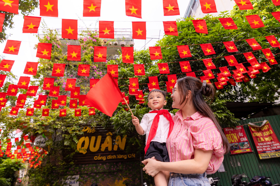 Chị Lê Hằng (Trung Hoà, Hà Nội) đã đưa con mình đến đây để chụp ảnh ghi lại khoảnh khắc đáng nhớ trong dịp trọng đại của dân tộc. (Ảnh: Minh Sơn/Vietnam+)