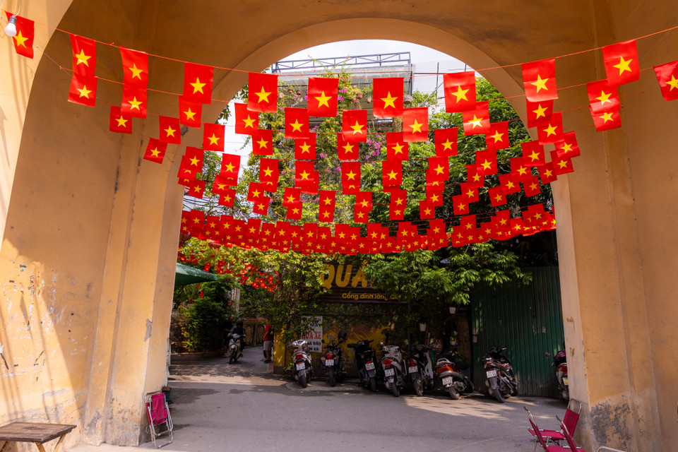 Cổng làng Cót (Yên Hoà, Hà Nội) được giăng đầy những lá cờ đỏ sao vàng khiến ai đi qua cũng phải ngước nhìn. (Ảnh: Minh Sơn/Vietnam+)