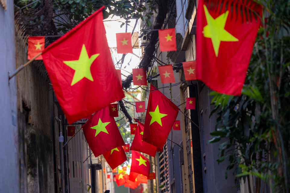 Lá cờ đỏ sao vàng tung bay phấp phới trên những góc nhà, ban công như những ngọn lửa nhỏ, thắp lên niềm tự hào dân tộc trong lòng mỗi người. (Ảnh: Minh Sơn/Vietnam+)