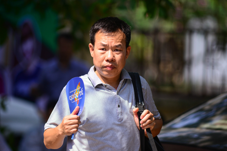 Một nhóm tình nguyện viên đã phát quạt cho phụ huynh của các sĩ tử. (Ảnh: Minh Sơn/Vietnam+)