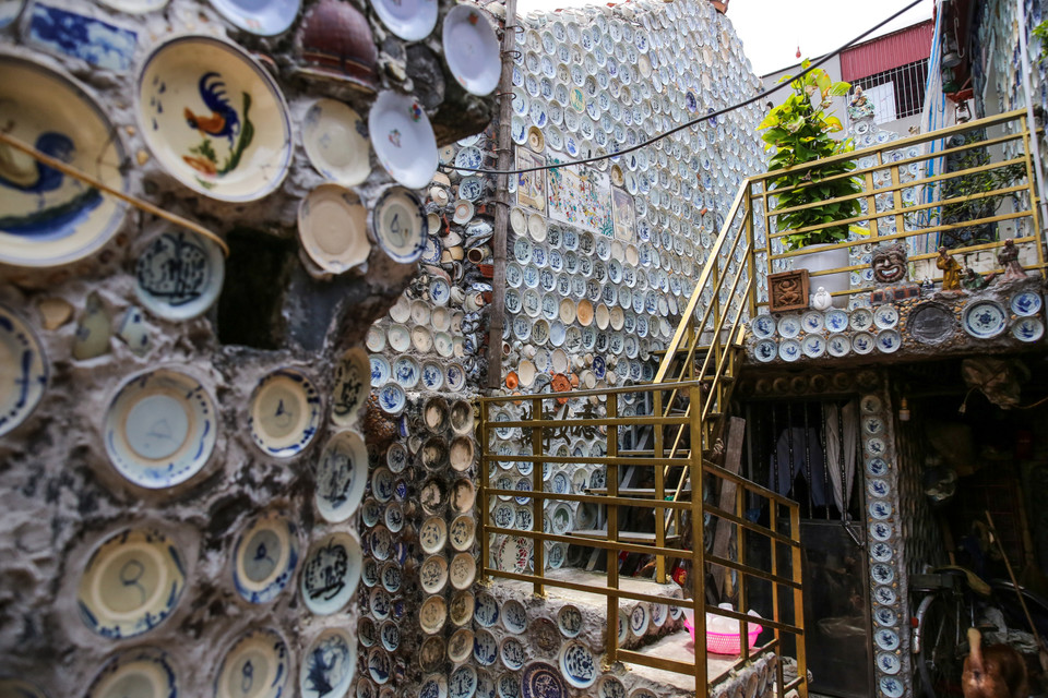 Con đường dẫn vào nhà ông Trường là một ngõ nhỏ lát bêtông, hai bên nhà cửa san sát. Ngay lối cổng vào, phía trên mái vòm được trang trí bằng những bình cổ xen kẽ với những chiếc bát đĩa cổ với đủ loại hoa văn, hình thù độc đáo. (Ảnh: Minh Sơn/Vietnam+)