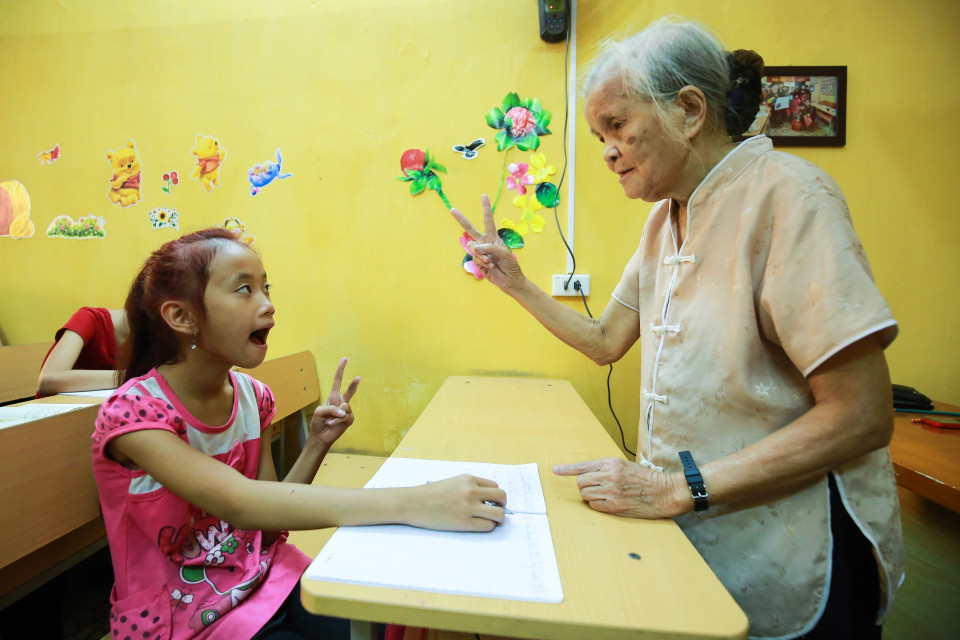 Lúc lại trò chuyện với một em bị khiếm thính bẩm sinh. (Ảnh: Minh Sơn/Vietnam+)