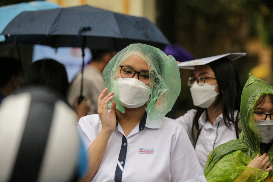 Trời đổ mưa lớn khiến các thí sinh khá vất vả để ra khỏi điểm thi. (Ảnh: Minh Sơn/Vietnam+)