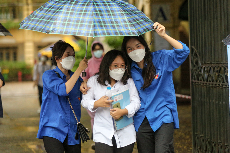 Lực lượng tình nguyện viên hỗ trợ đưa các thí sinh ra khỏi điểm thi. (Ảnh: Minh Sơn/Vietnam+)