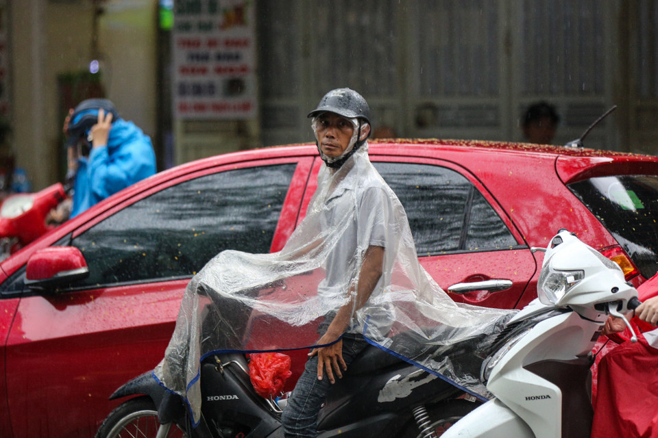 Trời Hà Nội đổ mưa lớn nhưng nhiều phụ huynh tại điểm trường Trung học Phổ thông Việt Đức vẫn kiên nhẫn chờ con em mình hoàn thành môn thi Toán. (Ảnh: Minh Sơn/Vietnam+)