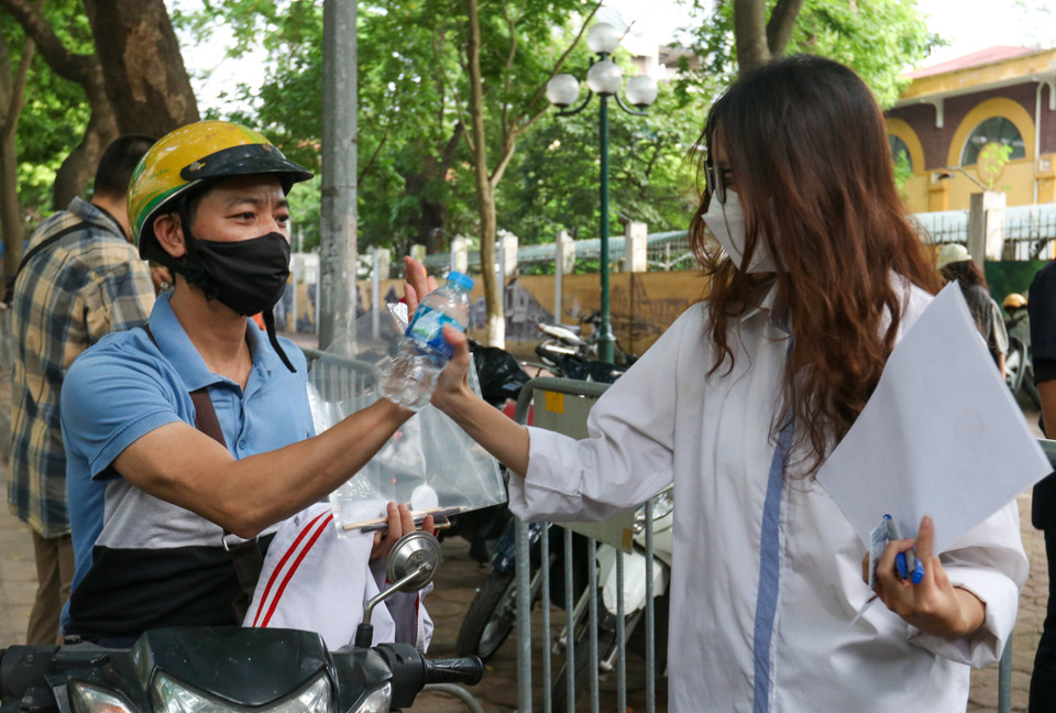 Phụ huynh đập tay động viên con trước khi bước vào môn thi đầu tiên. (Ảnh: Minh Hiếu/Vietnam+)