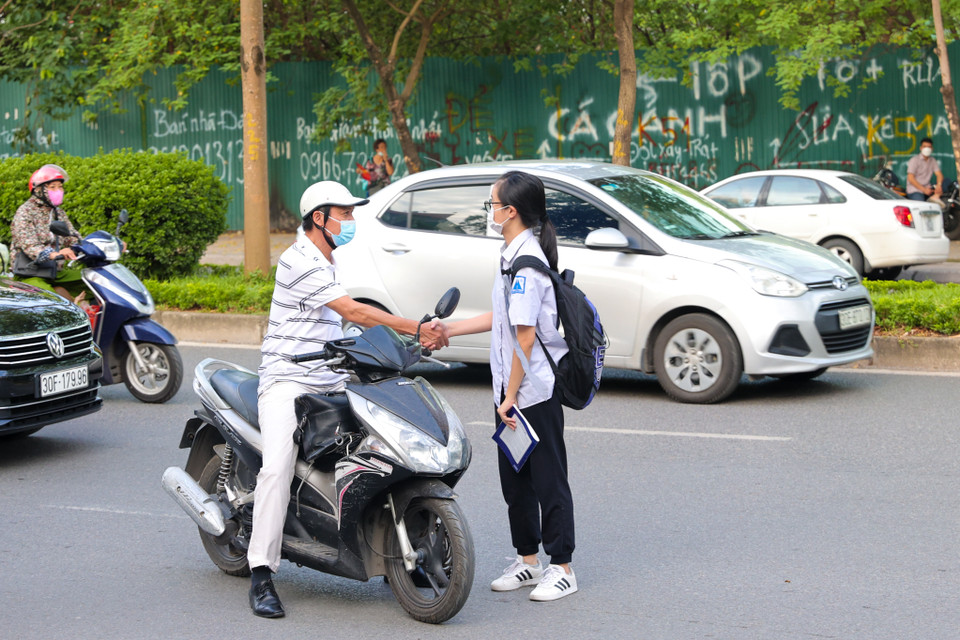 Nhiều phụ huynh bắt tay con em mình và chúc một kỳ thi diễn ra trọn vẹn tốt đẹp. (Ảnh: Minh Sơn/Vietnam+)