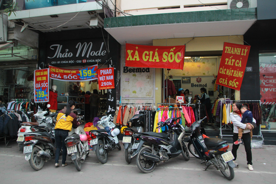 Đi dọc các con phố buôn bán đồ thời trang tấp nập ở Hà Nội như Chùa Bộc, Thái Hà, Cầu Giấy không khó để bắt gặp các cửa hàng thi nhau trưng biển giảm giá, xả hàng. (Ảnh: Minh Sơn/Vietnam+)