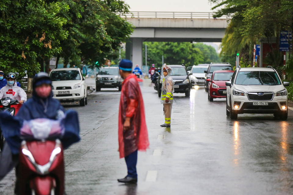 Tuy nhiên, vì trời đổ mưa lớn nên chốt kiểm soát này đã không dừng các phương tiện ôtô để tránh gây ùn tắc. (Ảnh: Minh Sơn/Vietnam+)