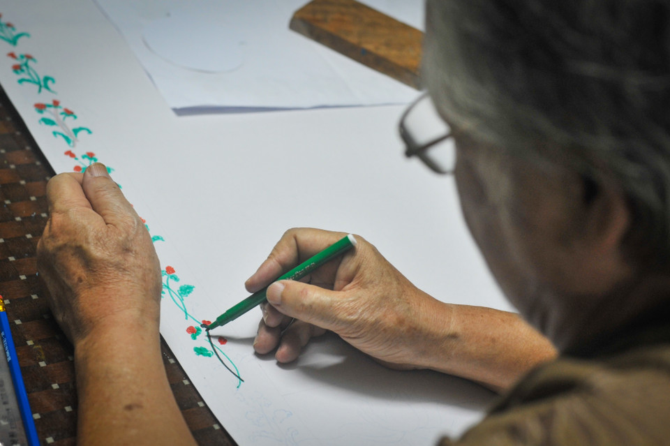 Ông cho biết, bây giờ báo tường chủ yếu được in, được thiết kế theo phong cách mới, nhanh hơn, đẹp hơn. Nhưng vẫn có nhiều học sinh muốn hướng về truyền thống, cứ ngày 20/11 là lại tìm đến nhà nhờ ông vẽ. (Ảnh: Minh Sơn/Vietnam+)