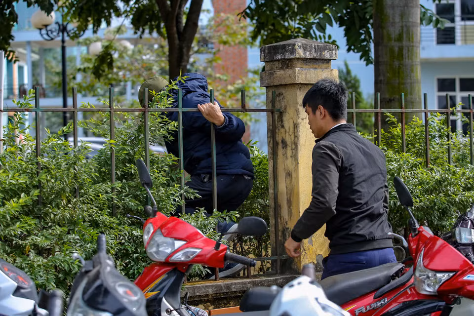 Nhiều người còn tìm được nơi rào bị gãy để chui vào bên trong. (Ảnh: Minh Sơn/Vietnam+)