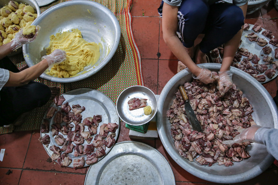 Gia đình cô Sáu ở làng Tranh Khúc gắn bó với nghề làm bánh chưng đã hàng chục năm nay. Cô Sáu cho biết ngày thường chỉ gói từ 200-300 cái, nhưng bắt đầu từ tháng Chạp lượng bánh gia đình cô gói nhiều hơn gấp 2-3 lần. (Ảnh: Minh Sơn/Vietnam+)