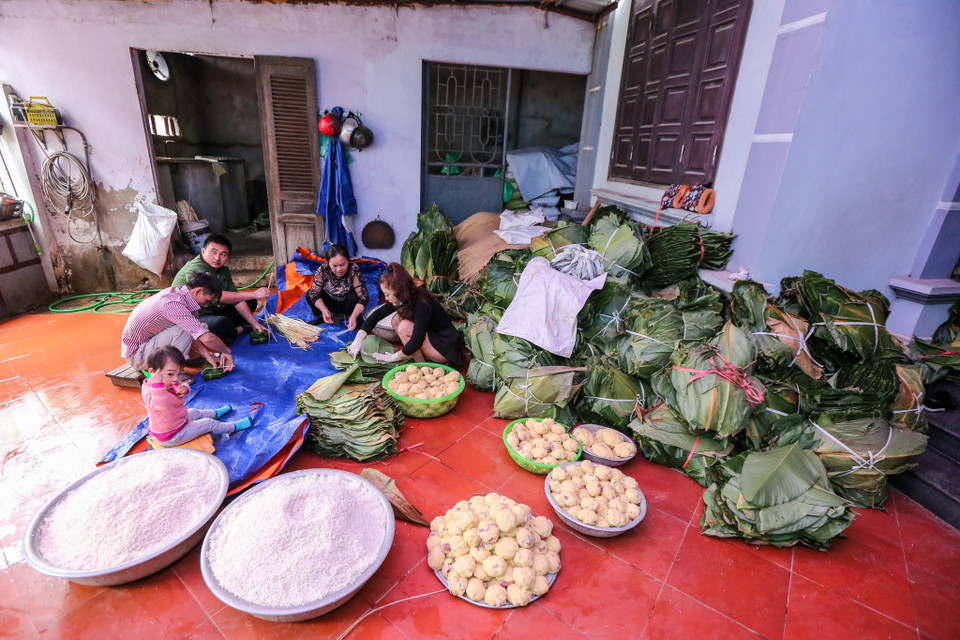 Ghé thăm làng Tranh Khúc những ngày này dễ dàng bắt gặp hình ảnh nhiều gia đình tất bật gói bánh với không khí sôi nổi, khẩn trương để kịp giao bánh cho khách hàng. (Ảnh: Minh Sơn/Vietnam+)