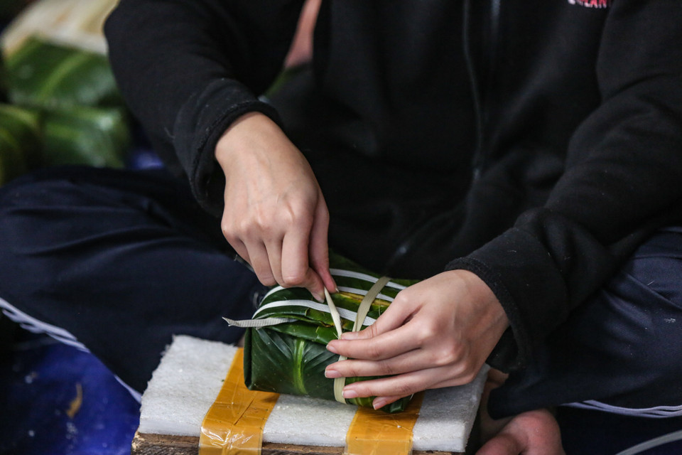 Người dân nơi đây cho biết gói bánh chưng không khó, nhưng từng công đoạn phải thật kĩ tỉ mỉ, kĩ lưỡng. (Ảnh: Minh Sơn/Vietnam+)