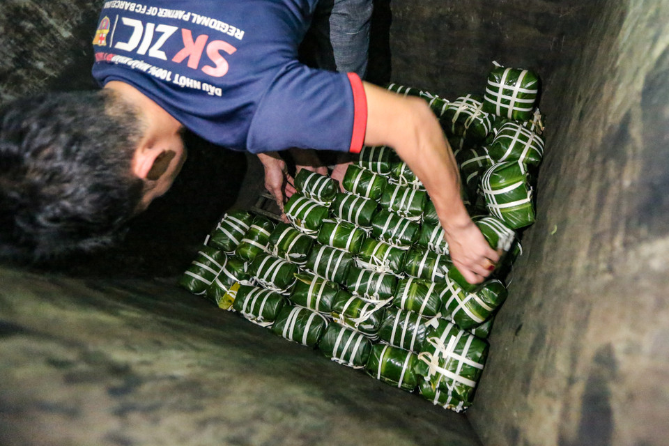 Sau khi sắp xếp ngăn nắp, bánh sẽ được nén với sức nặng vừa đủ và được đun trong nồi điện khoảng 8-10 tiếng. (Ảnh: Minh Sơn/Vietnam+)