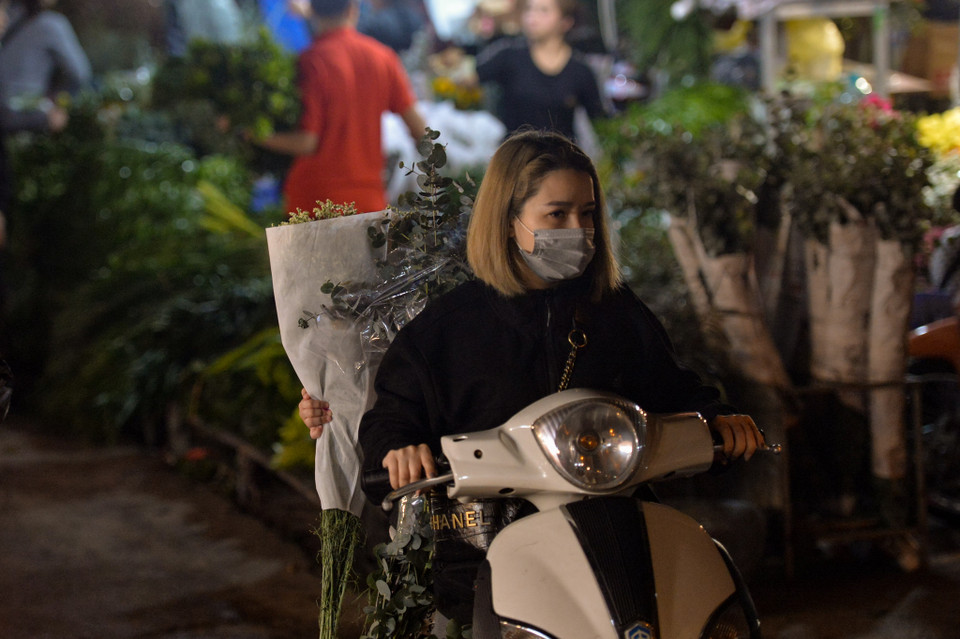 Chợ hoa Quảng An thường sẽ họp vào lúc 9 giờ tối đến nửa đêm. Các tiểu thương sẽ đi mua hoa từ các sạp hàng hoặc kho bán buôn. (Ảnh: Minh Sơn/Vietnam+)