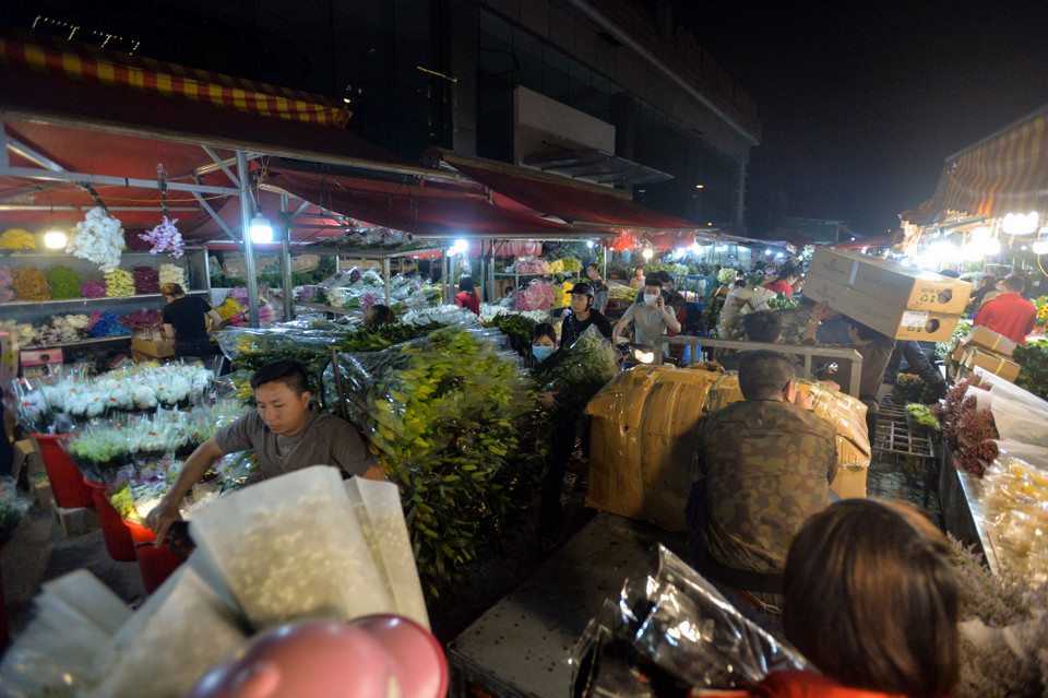 Cảnh các xe chở hàng trăm bông hoa di chuyển từng chút một trong khu chợ đã trở lại. (Ảnh: Minh Sơn/Vietnam+)