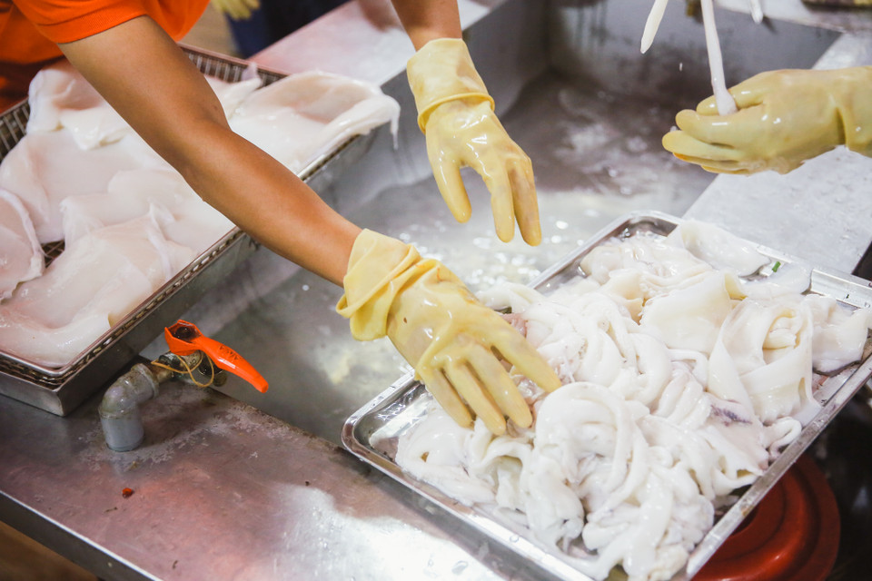 Hiện tại chả mực có 3 giai đoạn chính. Thứ nhất là chọn nguyên liệu và sơ chế qua. Tiếp đến là quá trình giã và trộn nguyên liệu. Quá trình cuối cùng là bỏ ra chiên. (Ảnh: Minh Sơn/Vietnam+)