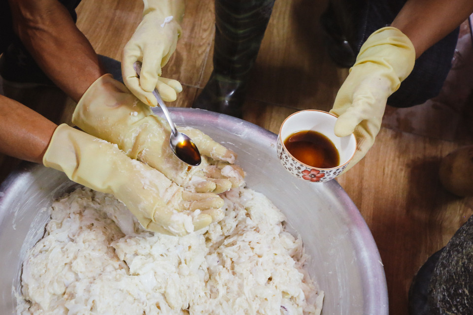 Trong suốt quá trình trộn thịt mực, người công nhân phải liên tục 'nếm' gia vị bằng cách.. ngửi mùi. Một lô chả mực ngon được xuất xưởng là bao tâm huyết của những người làm ra. (Ảnh: Minh Sơn/Vietnam+)