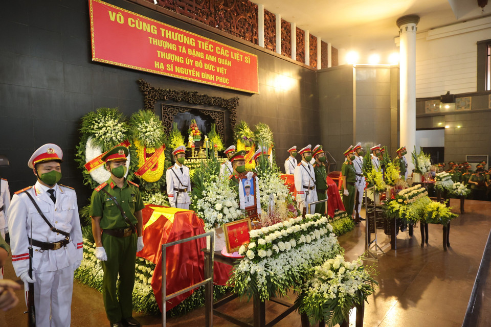 Các đồng chí, đồng đội đứng cạnh sát linh cữu các anh để chờ đến giờ phút tiễn đưa các anh về với đất mẹ. (Ảnh: Hoài Nam/Vietnam+)