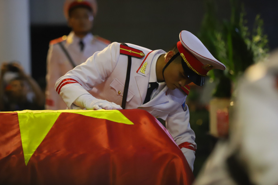 Linh cữu 3 liệt sỹ được thực hiện nghi thức phủ Cờ Bảo vệ an ninh Tổ quốc. (Ảnh: Hoài Nam/Vietnam+)